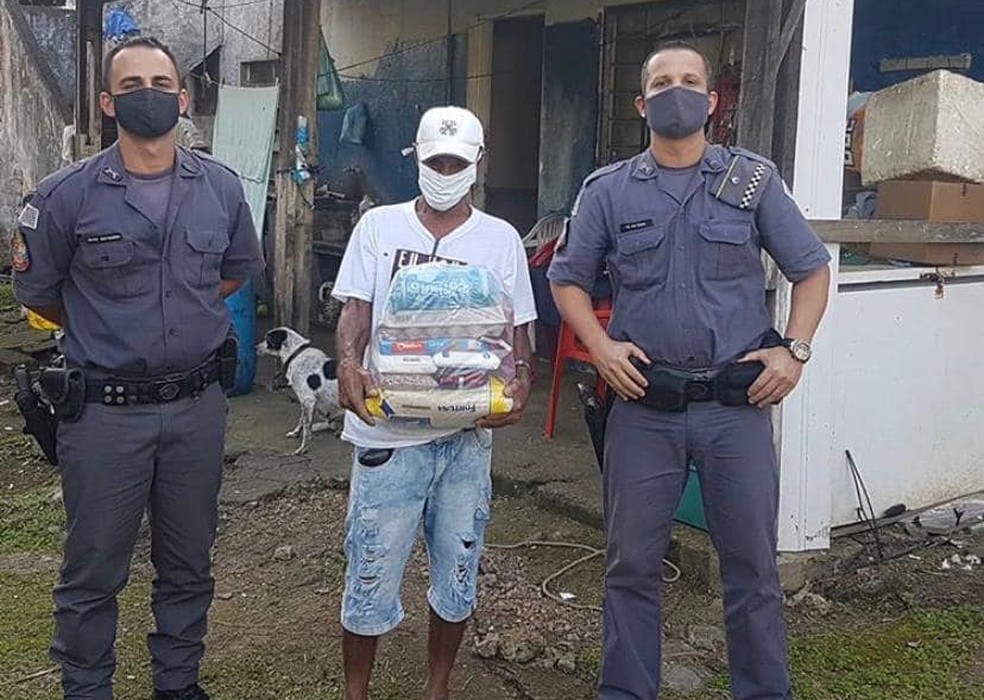 Mário Monteiro de Souza com os alimentos, entre os policiais que o ajudaram